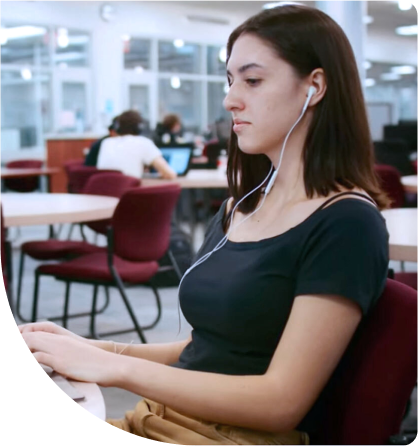 Student at the computer using Ellucian solutions to thrive.
